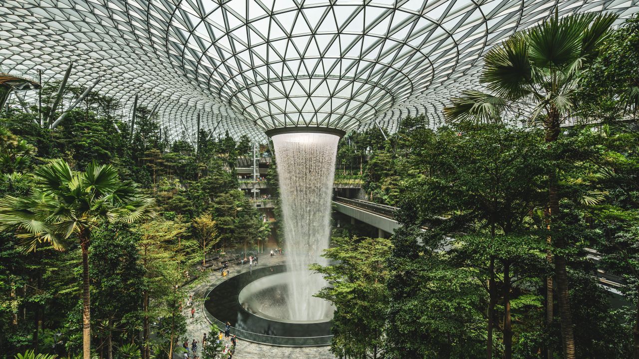The indoor waterfall at Jewel Changi Airport falling through rings of greenery