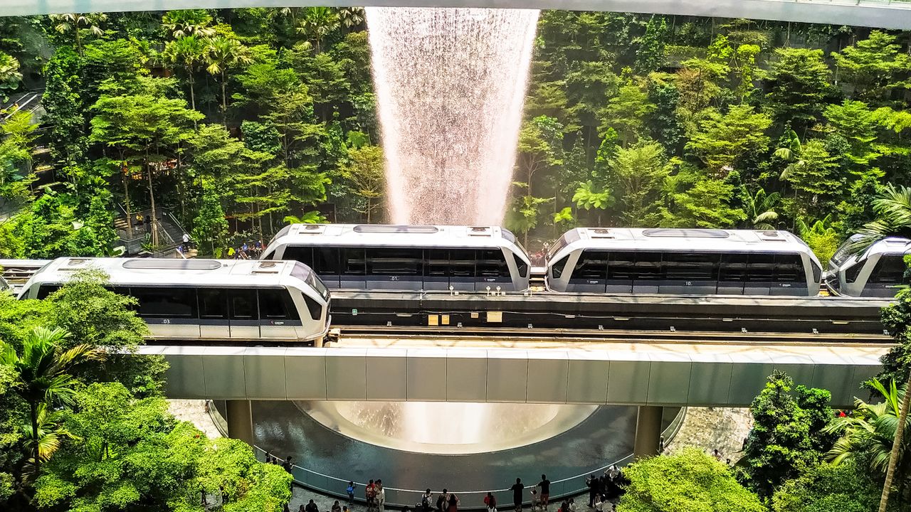 The Changi skytrain crossing in front of the Rain Vortex at Jewel
